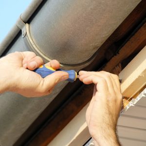 working hands screwing up under house roof outdoor