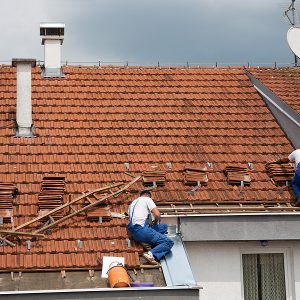 Two men working and fixing on the roof